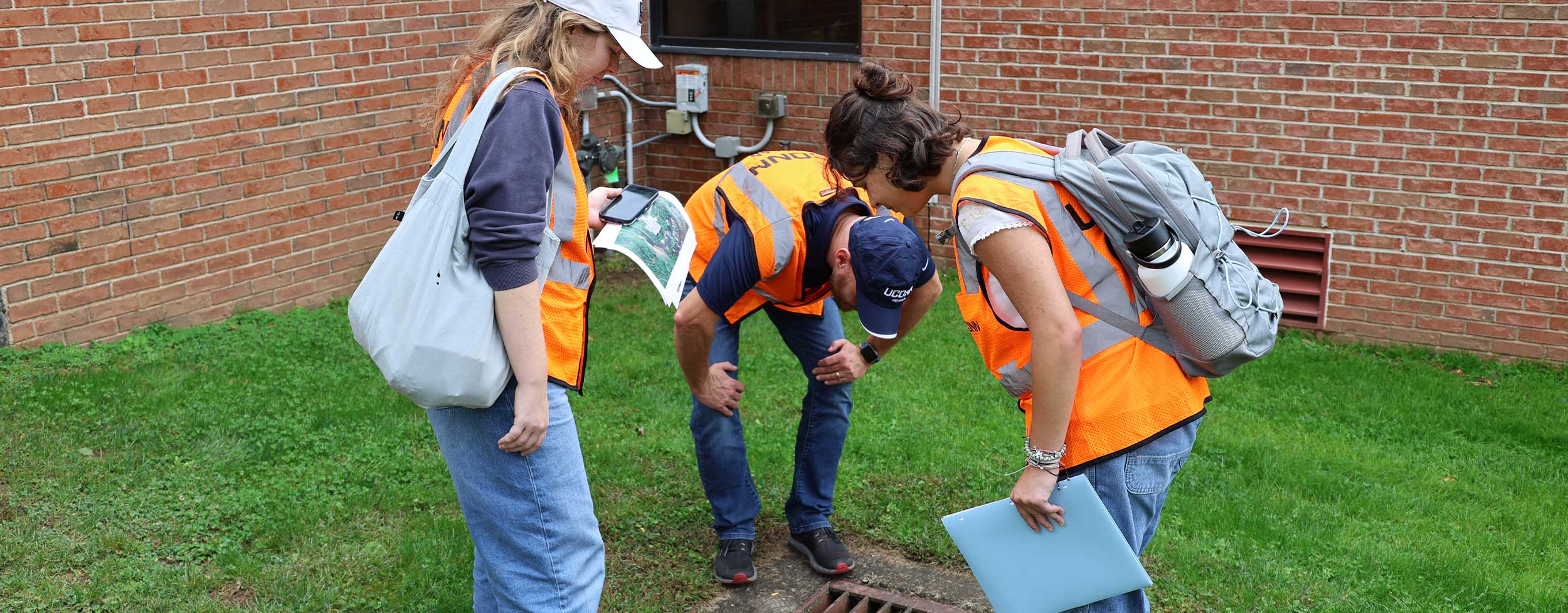 students looking into a stormwater drain